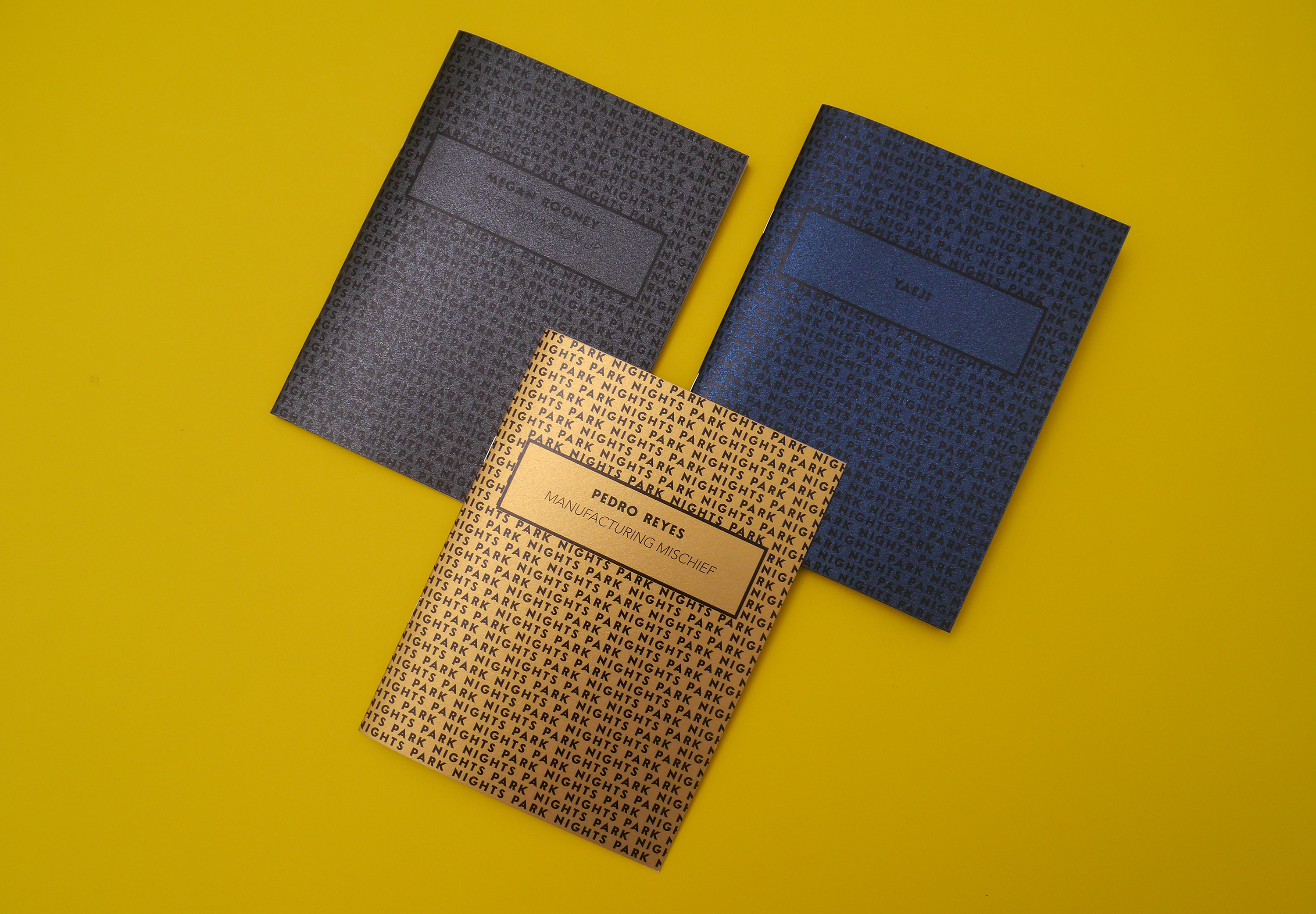 Three Park Nights programmes with metallic covers in gold, navy blue, and charcoal